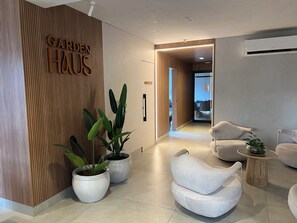 Eine moderne Hotelhalle mit einer Wand aus Holzdekor, Topfpflanzen und zeitgemäßen Sitzmöglichkeiten.