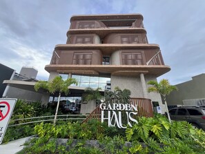 Ein mehrstöckiges Gebäude mit einem Schild, auf dem 'GARDEN HALL' steht.