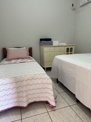Een slaapkamer met twee bedden, een kaptafel en een stopcontact.