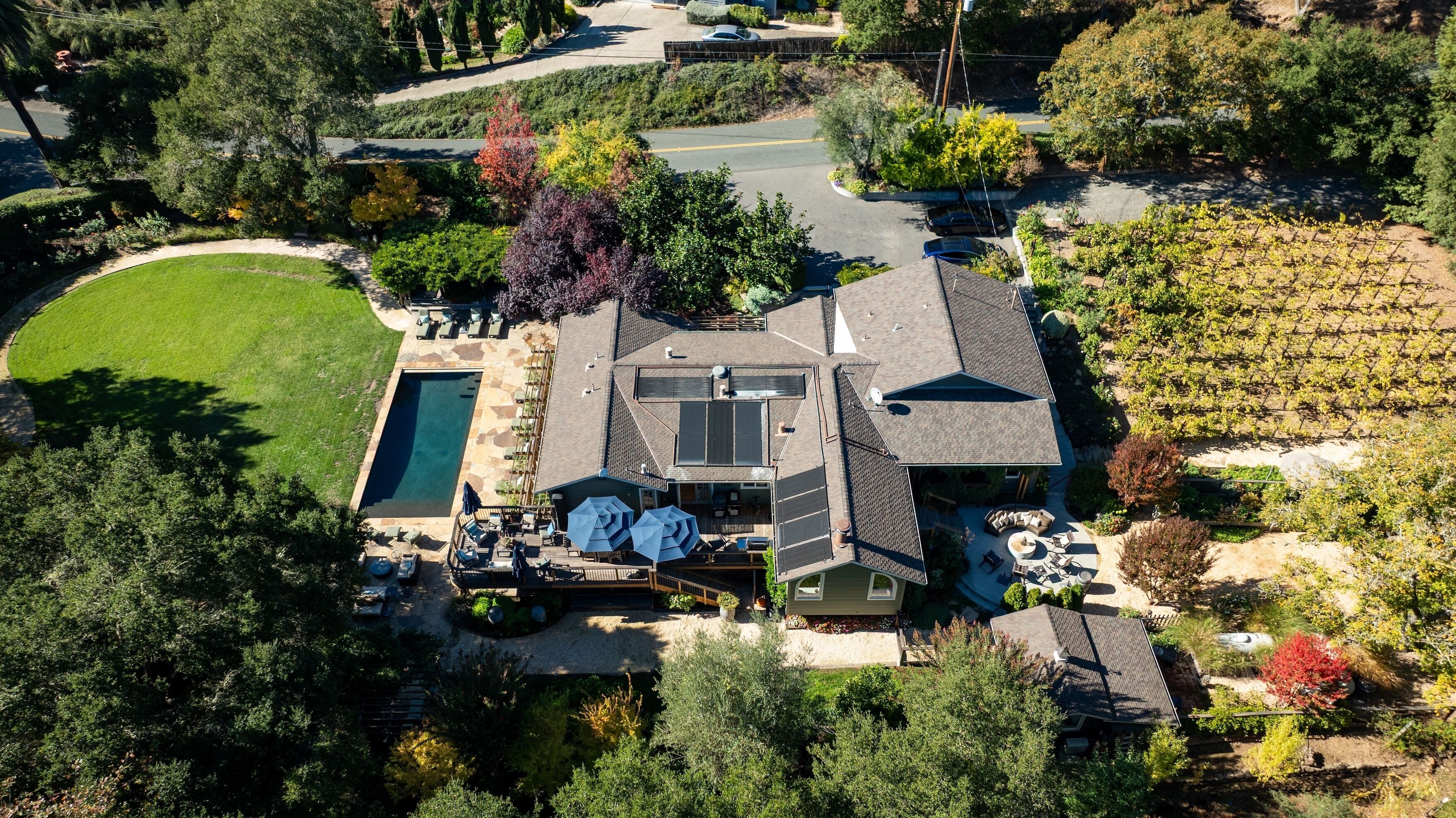A residential property with a swimming pool, patio, and a large garden area.