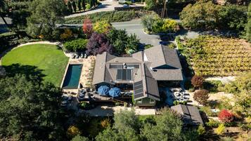 A residential property with a swimming pool, patio, and a large garden area.