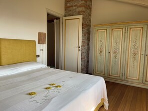 Une chambre à coucher comprenant un lit, une armoire, une porte et un mur orné d’un motif texturé.