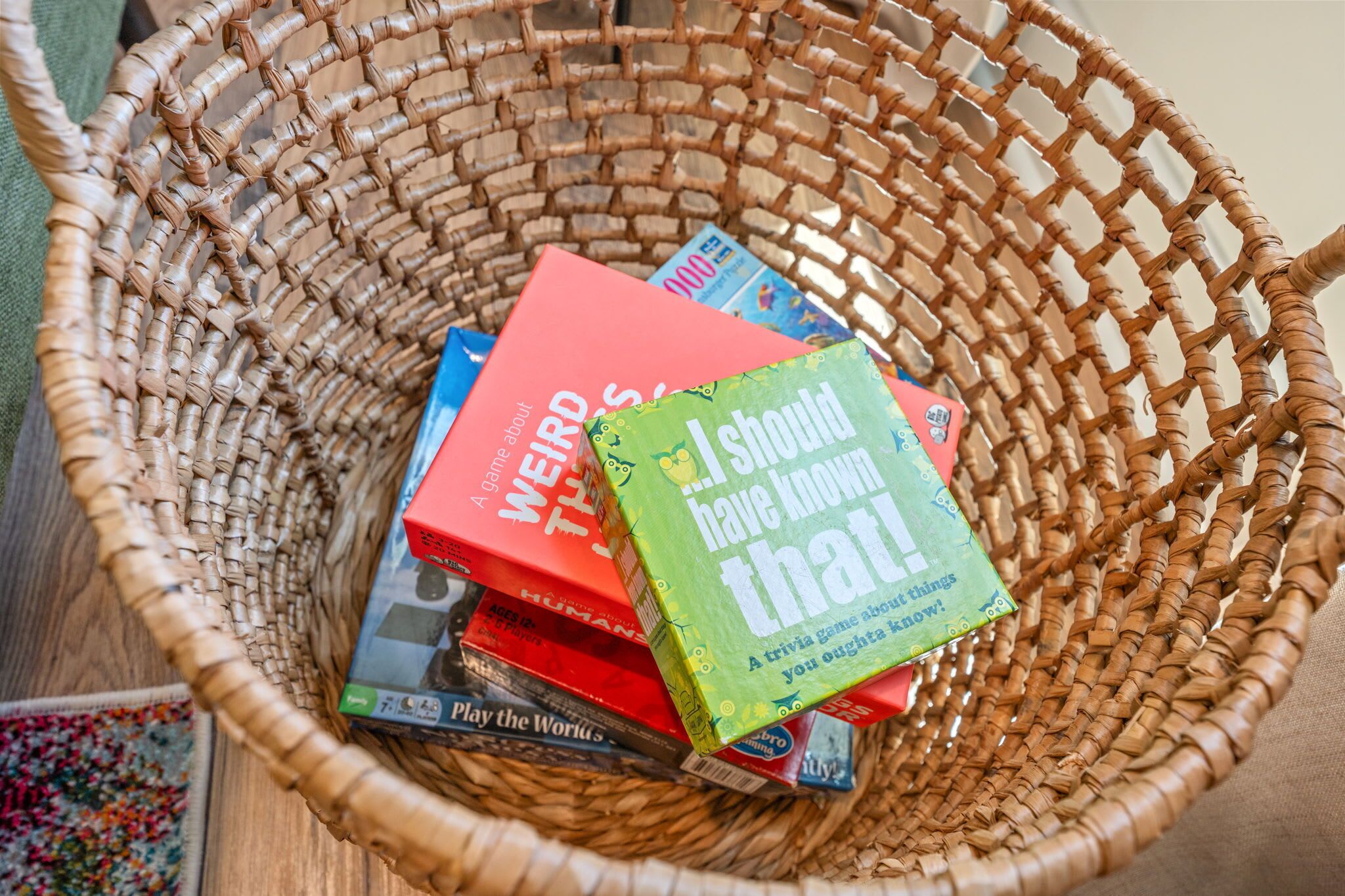 A wicker basket containing several board games.
