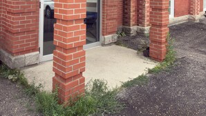 Un edificio in mattoni con un ingresso coperto e una porta ben visibile.