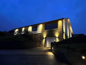 A modern house with a garage, a staircase, and a well-lit exterior. - Tigh-na-mara Retreat (Berwick-upon-Tweed)