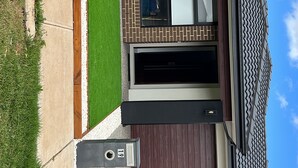 Ein modernes Gebäude mit flachem Dach und einer Ziegel-Fassade, bewölkter Himmel.