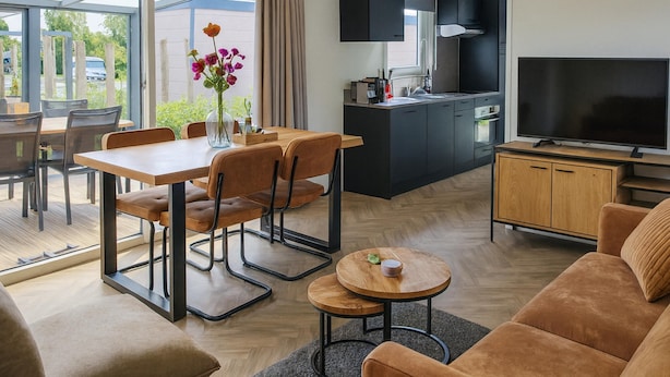 A modern living room with a dining area, a kitchen, and a TV. - Koudekerke Escape Near Dunes (Koudekerke)