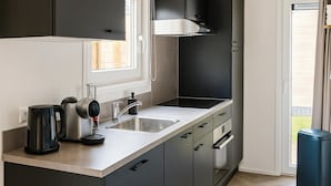 A modern kitchen with a built-in oven, a coffee maker, a sink, and a trash bin. - Koudekerke Escape Near Dunes (Koudekerke)