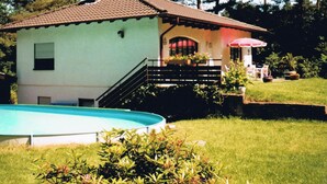 A house with a swimming pool, a staircase, and a garden.