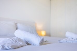 A neatly made bed with rolled white towels and a lamp in the background. - Rental unit in Albufeira · ★New · Studio · 2 beds · 1 private bathroom (Albufeira)