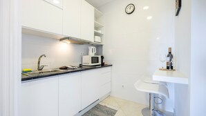 Eine moderne Küche mit weißen Schränken, einer Mikrowelle und einem Spülbecken.