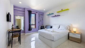 A modern bedroom with a bed, bedside table, and a desk with a chair.