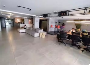 Ein moderner Büroraum mit Empfangsbereich, Sitzgelegenheiten und Arbeitsplätzen.