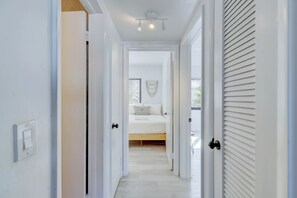 A hallway leading to a bedroom with a bed, a light switch, and a ceiling light fixture. - Boho, Resort with pool for 6 ppl - 5 min beach (Fort Lauderdale)