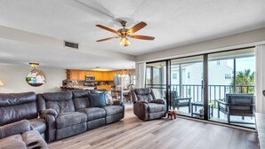 A spacious living room with a large sectional sofa, a recliner, and a ceiling fan. - Sea Club #42 - Stellar Escape (Indian Shores)