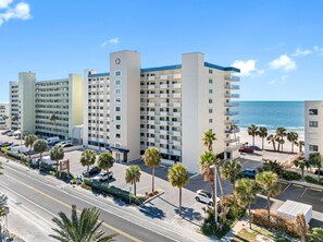 A multi-story hotel with a central tower, parking, and a beach view. - Sand Castle II #2603 - Premier (Indian Shores)