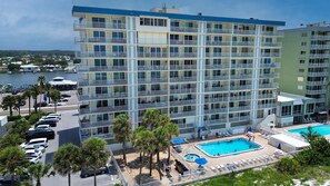 A multi-story hotel with a pool area, including sun loungers and umbrellas. - Sand Castle II #2603 - Premier (Indian Shores)