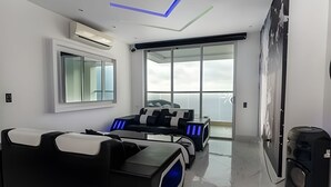 A modern living room with a sofa, a coffee table, and a large window. - Palmetto Beach - ILLUMINATO (Cartagena)