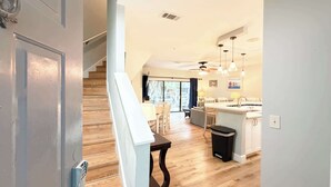 A modern kitchen with a central island, wooden flooring, and pendant lighting. - Ocean Breeze - Walk to Beach 3BR Lagoon View Villa (Hilton Head Island)