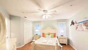 A bedroom with a bed, a ceiling fan, a dresser, a nightstand, and a window with blinds. - Ocean Breeze - Walk to Beach 3BR Lagoon View Villa (Hilton Head Island)