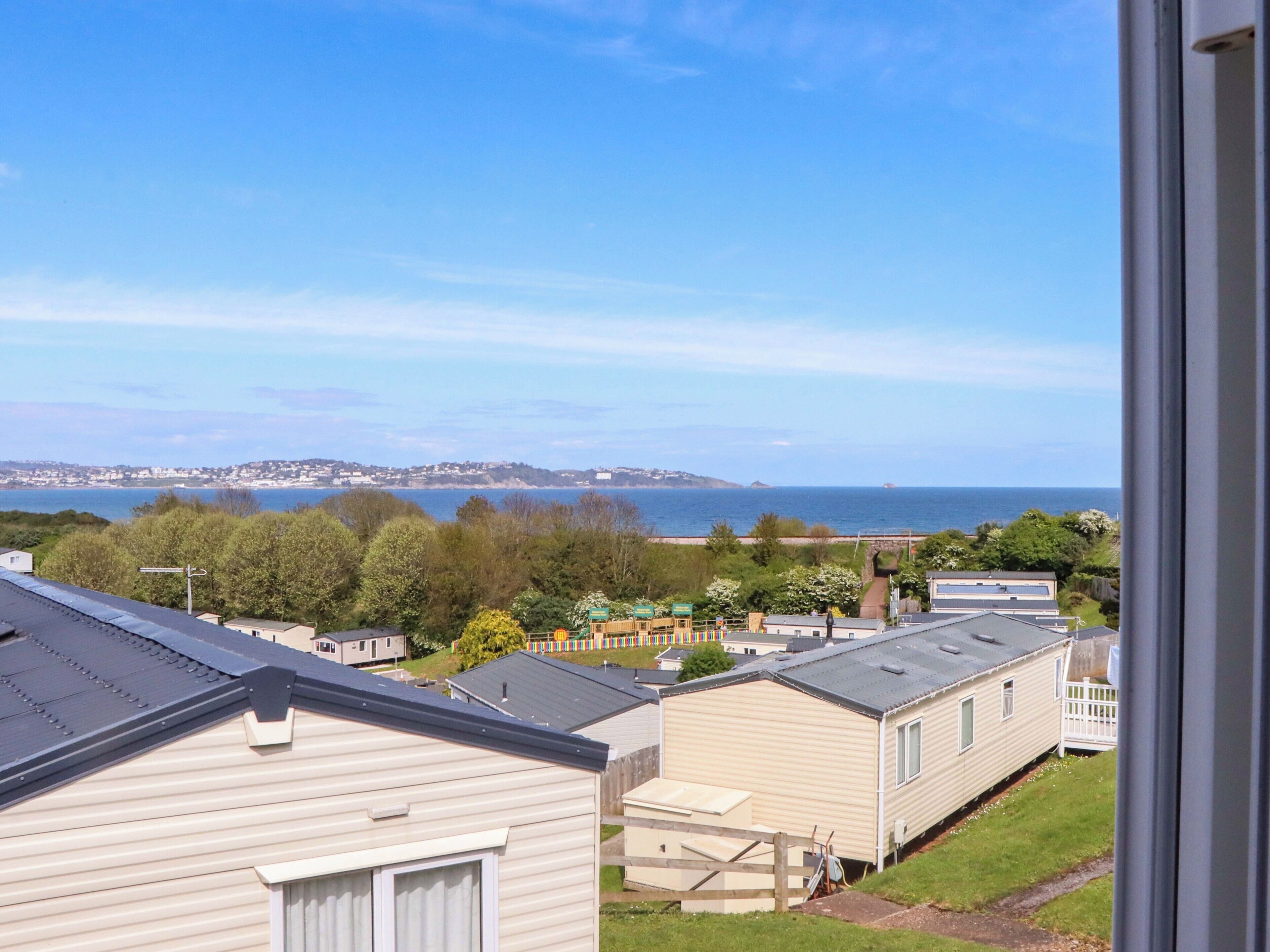 A view of a coastal area with mobile homes, a clear sky, and a distant shoreline.