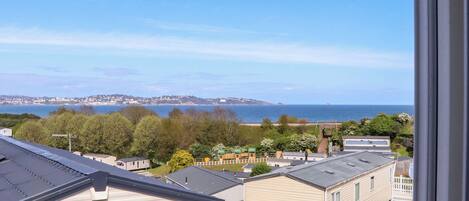 A view of a coastal area with mobile homes, a clear sky, and a distant shoreline.