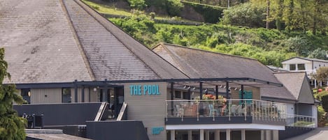 Un edificio con un cartel que dice 'THE POOL' y 'RECEPTION & SHOP', indicando una piscina y una tienda.