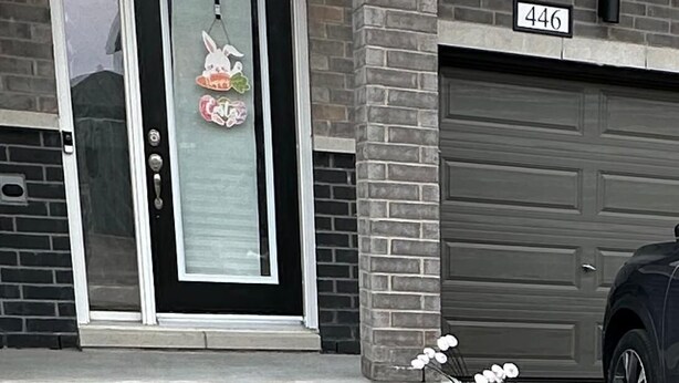A residential building with a garage door, a mailbox, and a house number 446.
