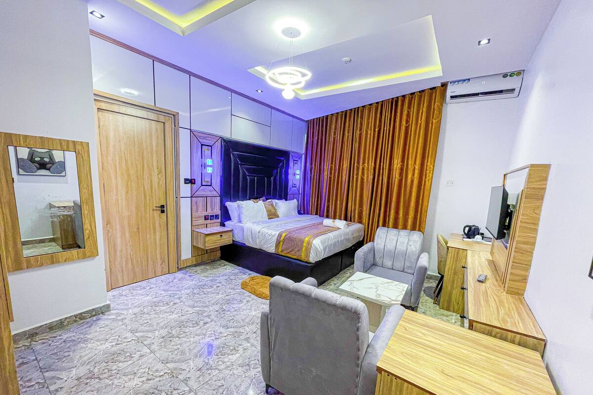 Una habitación de hotel moderna con cama, zona de estar y escritorio.