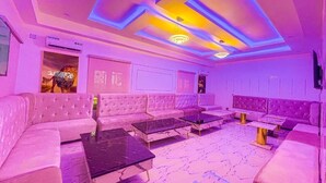 A room with a sectional sofa, a coffee table, and a TV. - Julicis Hotels and Suites (Lagos)