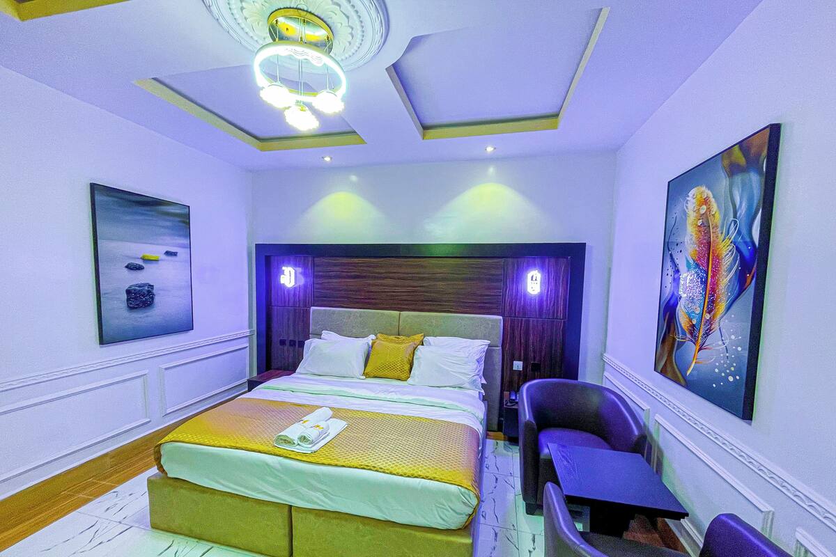 Una habitación de hotel moderna con una cama, un escritorio, una silla y un cuadro en la pared.