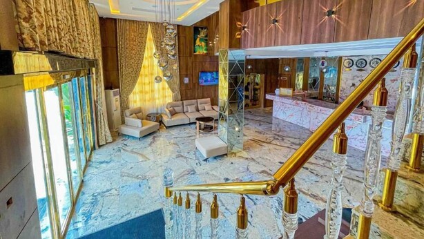A spacious lobby with a marble floor, a sofa, a chandelier, and a staircase with golden railings. - Julicis Hotels and Suites (Lagos)
