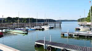 A marina with boats docked at wooden piers, calm water, and a clear sky. - Comfortable Apartment With a Private Sauna (gmina Stężyca)