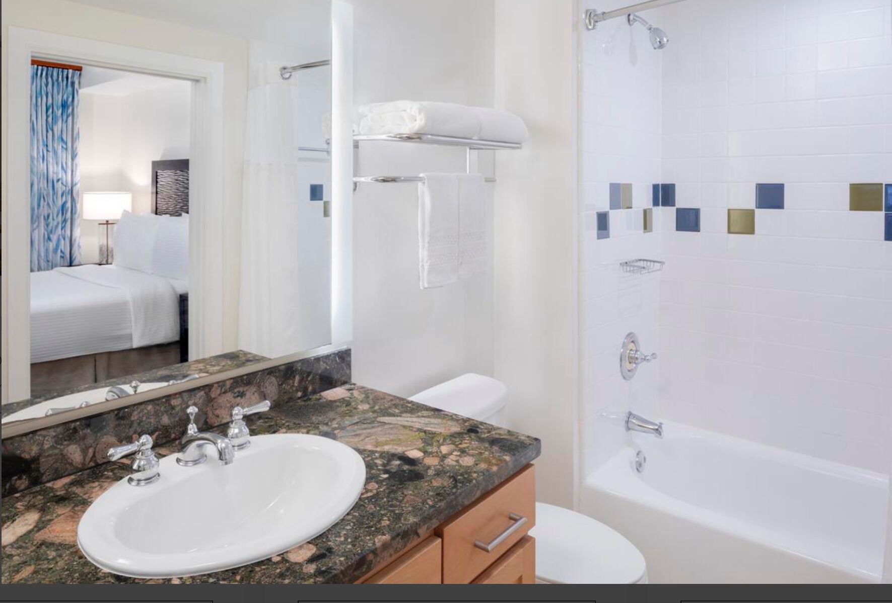 Une salle de bain équipée d’un lavabo, d’un miroir, d’un porte-serviettes, de toilettes et d’une douche.