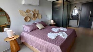 A modern bedroom with a large bed, bedside tables, a wardrobe, and decorative wall art. - Get One 607 · Flat Corais do Bessa with sea view for 4 people (João Pessoa)