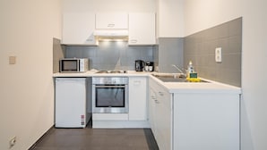 A compact kitchen with a microwave, stove, oven, and sink. - Amazing Apartment in Antwerp (Antwerp)