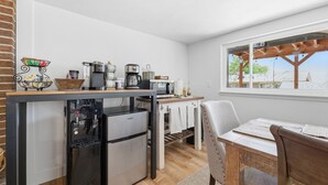 Een praktische keuken met een ingebouwd waterdispenser, een koffiezetapparaat en een magnetron.