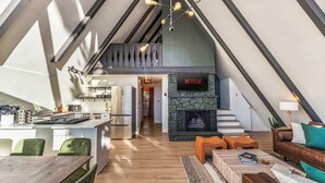 Un loft moderno con cucina, zona pranzo e soggiorno, caratterizzato da un camino e il logo Netflix.