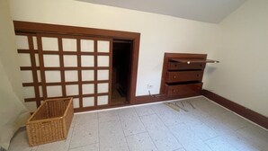 Een kamer met een schuifdeur, een houten dressoir en een rieten mand.