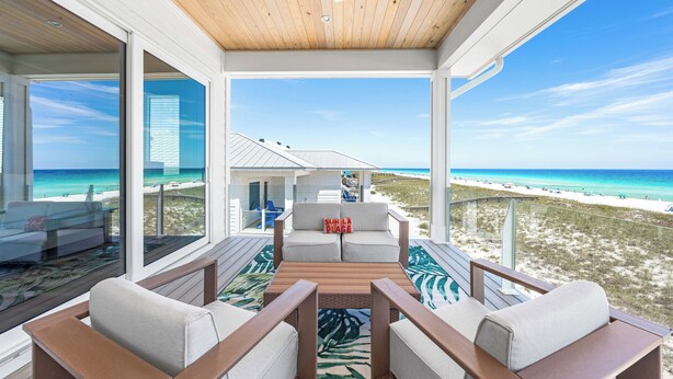 A modern beachside room with a wooden ceiling, large windows, and a view of the beach and ocean. - 💎 Share My Lowecation! Brand New Lux 6BR Beachfront! Pool, Pets, Sleeps 16 (Navarre Beach)