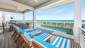 A deck with lounge chairs, a pool, and a view of the ocean. - 💎 Share My Lowecation! Brand New Lux 6BR Beachfront! Pool, Pets, Sleeps 16 (Navarre Beach)