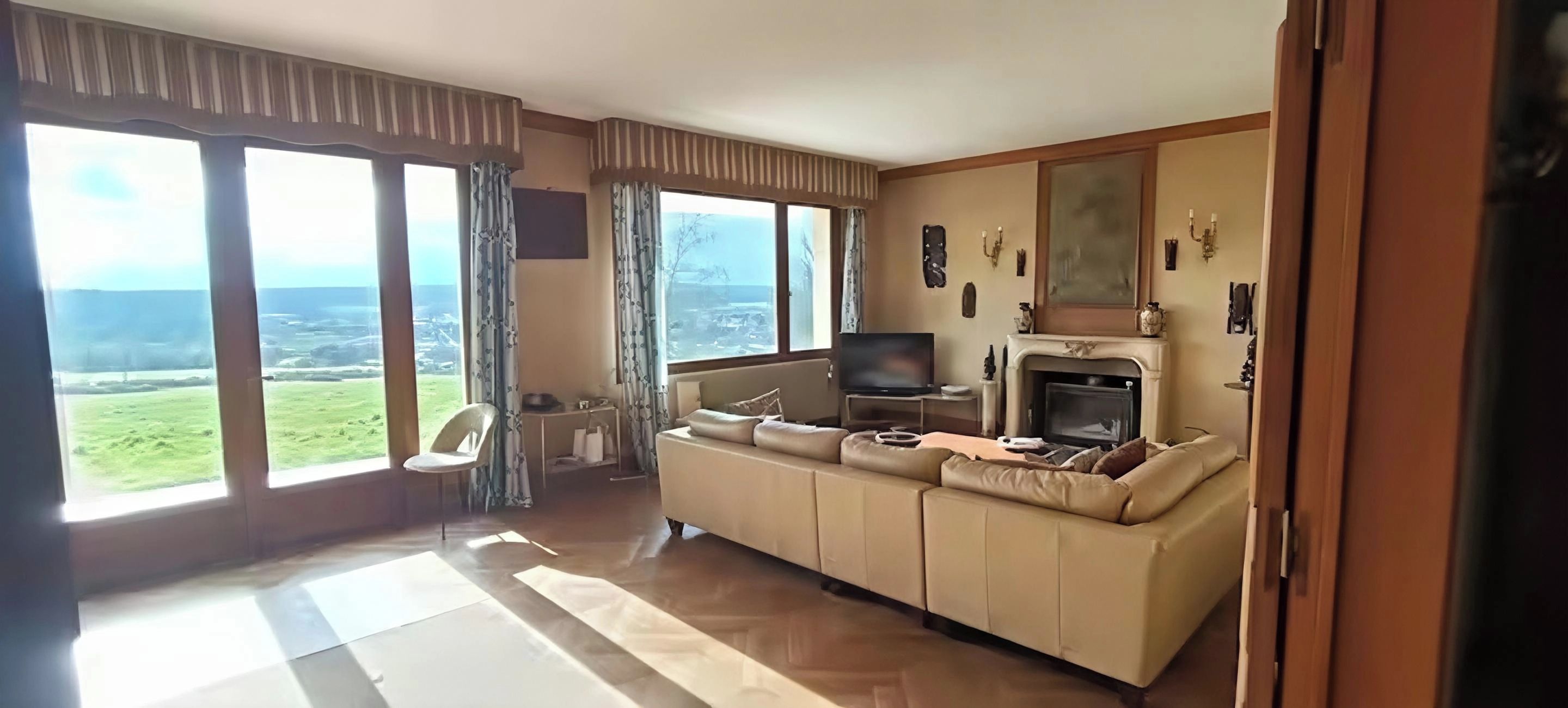 Ein Wohnzimmer mit einer Couch, einem Fernseher und einem Kamin.