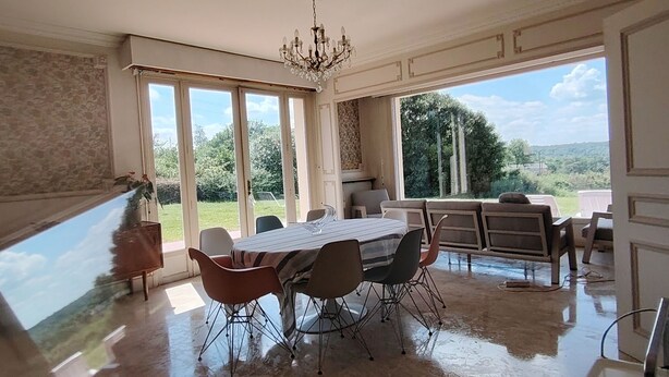 A dining area with a table and chairs, large windows, and a chandelier. - Normandy: Chic & Authentic (Beaumont-le-Roger)