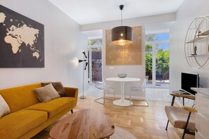 Un saló modern amb un sofà, una taula de centre i una zona de menjador amb cadires i una taula.