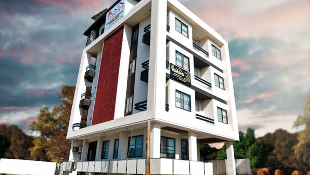 A multi-story hotel with a modern design, featuring balconies and a prominent red accent wall. - Vijaya's Homestay Indore (Indore)