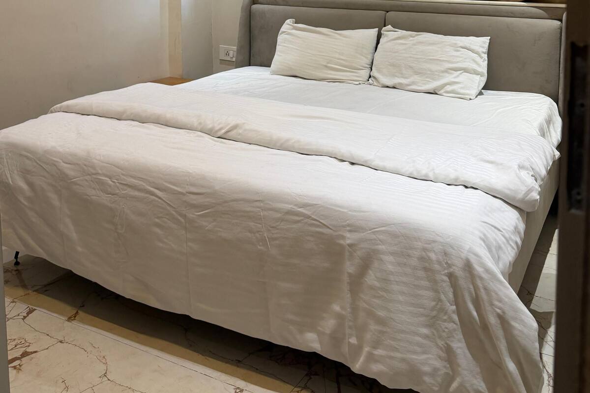 Un dormitorio con cama, cabecera y ventilador de techo.