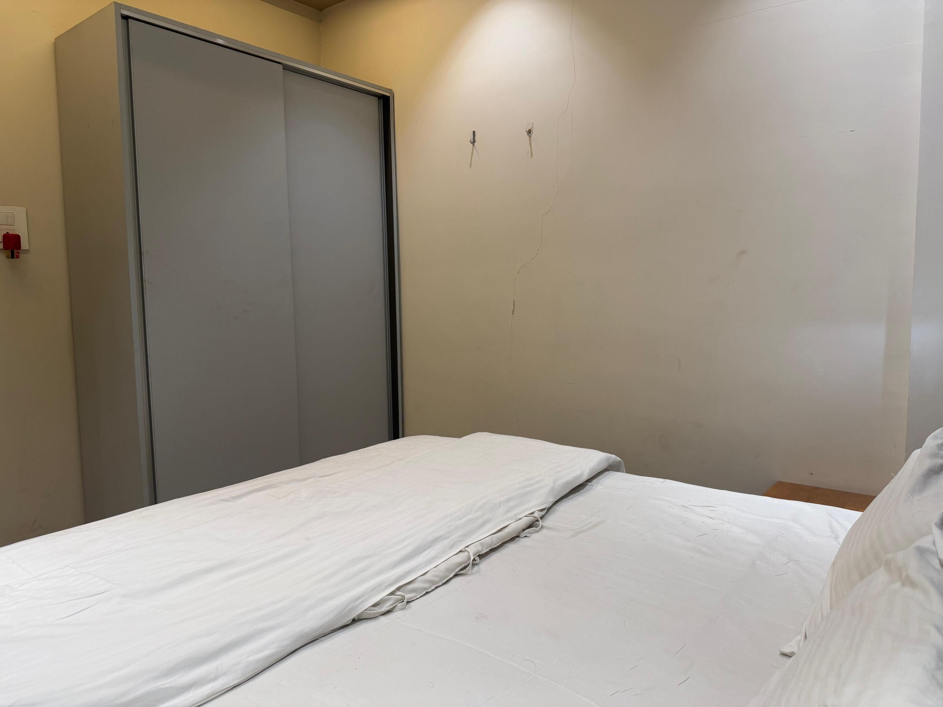 Ein Schlafzimmer mit einem Bett, einem Kleiderschrank und einer Steckdose.