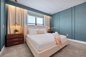 Una camera da letto con un letto, comodini, una cassettiera e una finestra con tende.