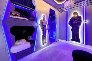 Ein Zimmer mit einem Etagenbett, einer Roboterfigur und einer Wanddekoration.