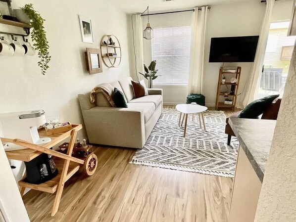 Ein Wohnzimmer mit einer Couch, einem Couchtisch und einem Fernseher.